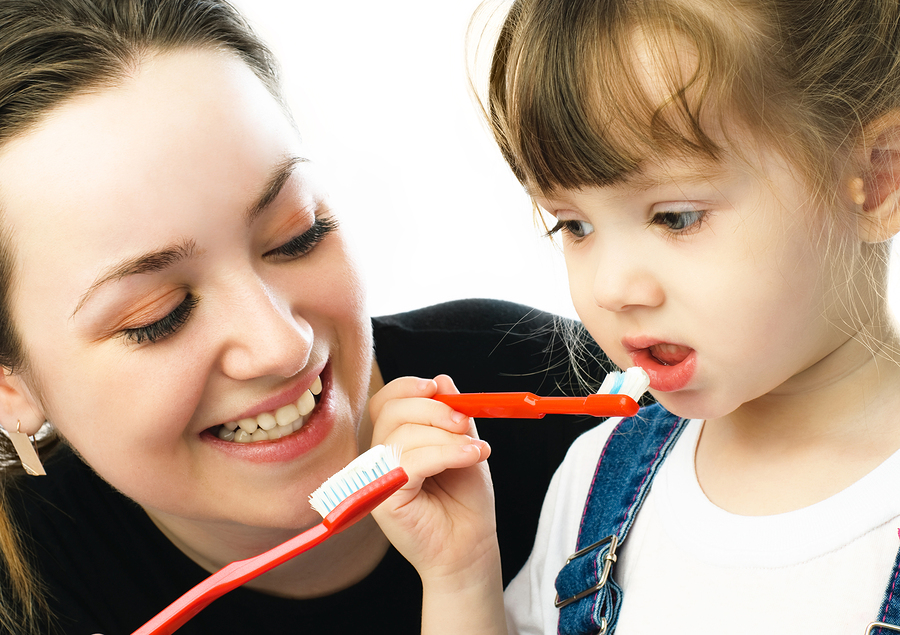 mom showing toddler daughter how to use a toothbrush and brush her teeth, Windsor Locks, CT pediatric dentistry